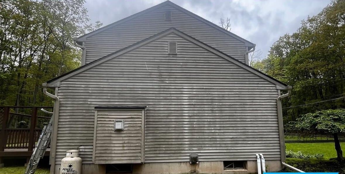 Before — Algae-stained vinyl siding on a lakeside Pocono home, washed clean